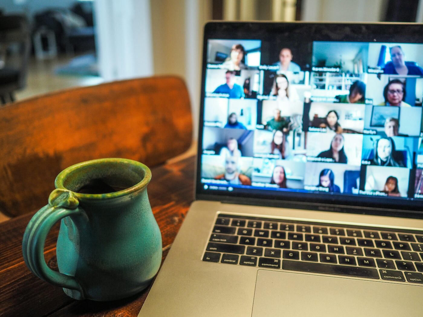 Zoom call with cup of tea Laptop with a video call meeting on a wooden table with a teal pottery mug. Photograph by Chris Montgomery on Unsplash.
